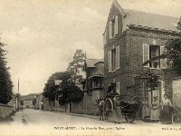 Grande rue  Vue en direction des Andelys | Voiture  cheval en livraison et femmes posant devant l'entre de la cour de l'actuel caf de la mairie sis au n104  qui faisait alors office de salle de danse (les piliers du portail et le portillon ont aujourd'hui disparus) |  gauche la croix nimbe de l'glise St-Pierre et au centre les "annexes" de la villa de l'ingnieur Schmid.
