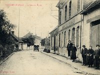 Grande rue  Vue en direction de Vernon | Habitants posant devant l'tablissement LEFEBVRE sis au n105  : Vin, caf, billard. Sur la gauche se trouve l'actuel parking de l'Auberge des Pcheurs celle-ci se trouvant dans la maison situe derrire la Renault du photographe A.Lavergne.